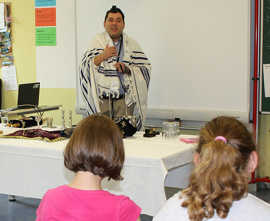 Arie Rosen stellt den Schülern den Tallit vor, einen Gebetsmantel mit langen weißen Fäden.