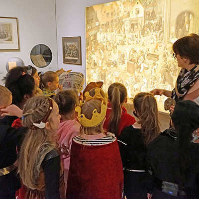 Kuratorin Dorothée Henschel führt bunt kostümierte Kinder der Grundschule am Dom durch die Ausstellung. Foto: Stadtmuseum