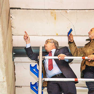 Baudezernent Andreas Ludwig (l.) und Rainer Lehnart, Ortsvorsteher von Feyen/Weismark, begutachten die beschädigten Gasbetonplatten im Dach der Bezirkssporthalle aus nächster Nähe.