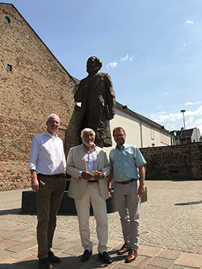 OB Wolfram Leibe, Mario Adorf und Mayens OB Wolfgang Treis (v. l.) vor der Marx-Statue auf dem Simeonstiftplatz.