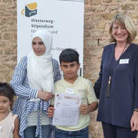 Mazen Mabrouke präsentiert stolz seine Diesterweg-Urkunde. Mit auf dem Foto sind seine Mutter, seine Schwester und Sabine Plate-Batz von der Nikolaus-Koch-Stiftung.
