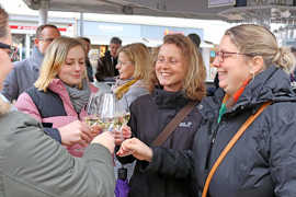 Vier Damen stoßen zur Eröffnung des Weinstands auf dem Hauptmarkt an.