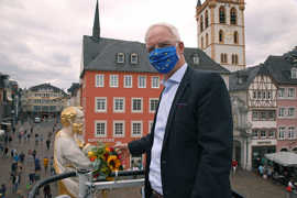 Wolfram Leibe hat der Petrusfigur auf dem Hauptmarkt den traditionellen Blumenstrauß in den Stadtfarben Gelb-Rot überreicht.