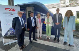 Gruppenfoto mit sechs Personen, ide auf einem Bahnsteig vor dem blauen Führerhaus eines Zugs mit der Aufschrift Regiolis stehen.