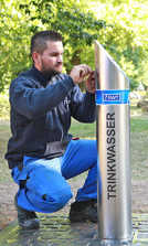 SWT-Mitarbeiter Michel Niemas installiert den neuen Trinkwasserspender im Palastgarten. Foto: SWT 