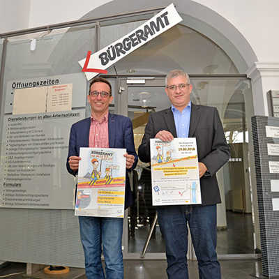 Dezernent Thomas Schmitt (l.) und Amtsleiter Guido Briel präsentieren die Plakate, mit denen auf den Umbau des Bürgeramts, der am 19. März startet, aufmerksam gemacht wird. 