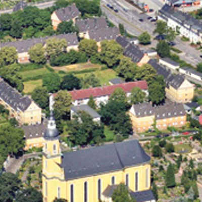 Das Luftbild zeigt im Vordergrund die Paulinkirche mit dem angrenzenden Friedhof. Nördlich davon liegt die Eisenbahnersiedlung aus den 20er und 50er Jahren. Auf der zentralen Freifläche sollen neue Wohnungen und ein Spielplatz entstehen.