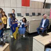 Kinder aus der ukrainischen Partnerstadt Isjum überbringen Oberbürgermeister Wolfram Leibe Gastgeschenke. Sie hatten neben der ukrainischen Flagge eine aufwändige Stickerei in einem Bilderrahmen mit dabei, die künftig einen Platz im Rathaus finden wird.