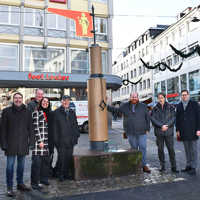 Gruppenbild von sieben Personen vor dem Pranger in der Grabenstraße