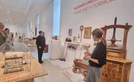 Eine Besuchergruppe wird durch eine Abteilung der Ausstellung mit alten Haushaltsgeräten geführt.