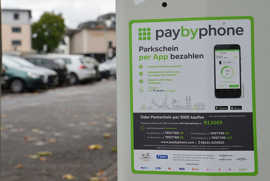 Aufkleber an den Parkscheinautomaten am Augustinerhof weisen auf die Option des bargeldlosen Bezahlens der Parkgebühr via App oder SMS hin. 