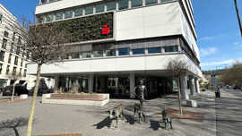 Teilansicht eines Bürogebäudes mit dem roten Symbol der Sparkasse