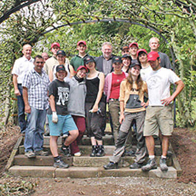 Gruppenfoto der Camp-Teilnehmer und ihrer Betreuer mit Beigeordnetem Ulrich Holkenbrink auf einer renovierten Treppe.