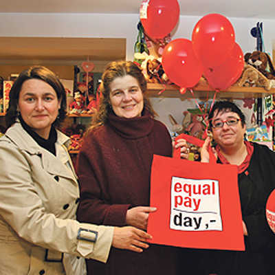 Frauenbeauftragte Angelika Winter, Bürgermeisterin Angelika Birk und Martina Ackermann, (ver.di, v. l.), machen mit roten Taschen und Ballons in einem Spielwarengeschäft in der Neustraße auf die Entgeltunterschiede aufmerksam.