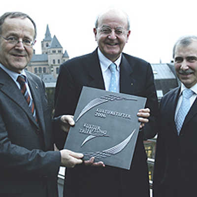 Hans-Hermann Kocks, Vorsitzender des Vorstands der Trierer Kulturstiftung, überreicht ein Kultustifter-Tafel an die Sparkassen-Vorstände Dieter Mühlenhoff (l.) und Remigius Kühnen (r.).