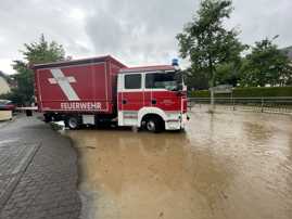 Feuerwehrwagen im Wasser des Bachs