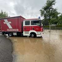 Feuerwehrwagen im Wasser des Bachs