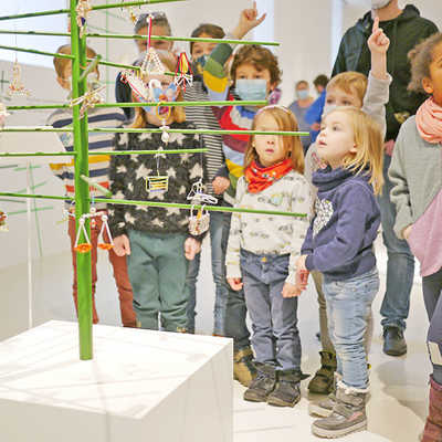 Ein Weihnachtsbaum in der Ausstellung ist mit Miniaturgeschenken geschmückt. Foto: Stadtmuseum