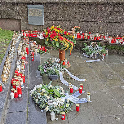 Nahe der Porta Nigra können Menschen im Gedenken an die Opfer der Amokfahrt Kerzen und Blumen abstellen. Vor gut einer Woche wurde dort eine Plakette (hinten) angebracht.