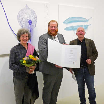 Kulturdezernent Markus Nöhl (Foto oben Mitte) präsentiert die Urkunde für den Ramboux-Preis, die er zuvor Clas Steinmann verliehen hat. Maria Steinmann freut sich über die Ehrung für ihren Ehemann. Foto: Stadtmuseum