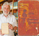 Werner Schättgen freut sich über die Übergabe des wertvollen Kochbuchs an die Wissenschaftliche Bibliothek der Stadt Trier. Auf dem Titel (rechts) ist eine Köchin beim Servieren eines Gerichts zu sehen. Foto: Anja Runkel
