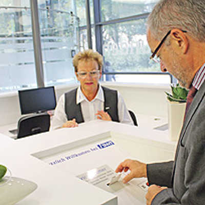 Oberbürgermeister Klaus Jensen testet im Beisein einer SWT-Mitarbeiterin das neue Wartemarkensystem.