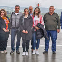 Gruppenbilde mit Besuchern und Gastgebern auf der Plattform eines Hubschrauberlandeplatzes