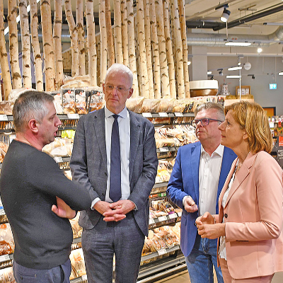 Beim Ortstermin im Lebensmittelmarkt mit Ministerpräsidentin Malu Dreyer (r.) und OB Wolfram Leibe (2. v. l.) berichten Geschäftsführer Wladimir Pojanow (l.) und Thomas Müller (Kylltal Reisen, 2. v. r.) über ihre Erfahrungen während und nach der Flutkatastrophe.