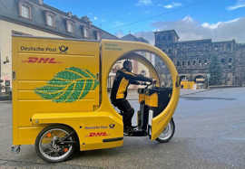 Ein gelbes Lastenfahrrad dient als Auslieferungsfahrzeug der Post