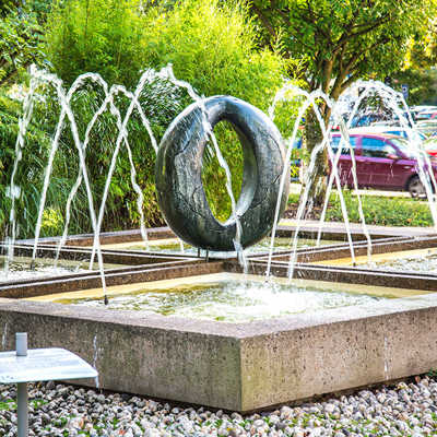 „Dieser Brunnen ist ein Zeugnis seiner Entstehungszeit, dem Jahr 1965“, heißt es erläuternd auf der 2012 eigens installierten Infotafel (l.). Bemühungen zur Umgestaltung gab es schon mehrere. 