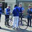 Vier Mitarbeiter des Ordnungsamts umringen eine Person mit einem Fahrrad in der Fußgängerzone
