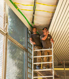 Mitarbeiter der Firma CWD Bausanierung überprüfen und sanieren die Sporthallendecke der Medard-Förderschule.