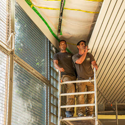 Mitarbeiter der Firma CWD Bausanierung überprüfen und sanieren die Sporthallendecke der Medard-Förderschule. Die Arbeiten laufen nach Plan.