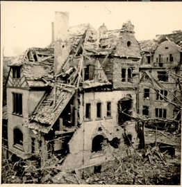 Schwarz-Weiß-Foto von durch Bombenangriffe stark zerstörten Wohnhäusern mit eingestürzten Dachstühlen
