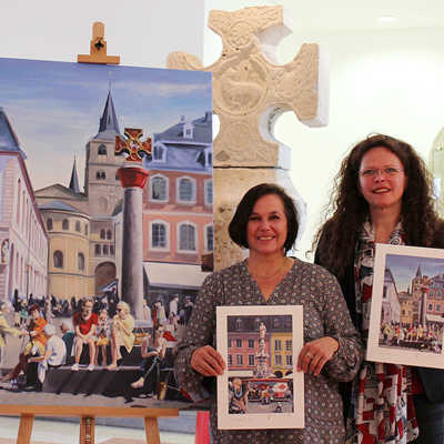 Martina Diederich (l.) und Dr. Bärbel Schulte präsentieren im Stadtmuseum die neuen Kulturaktien vor einem der beiden Original-Gemälde und dem Original-Marktkreuz. 