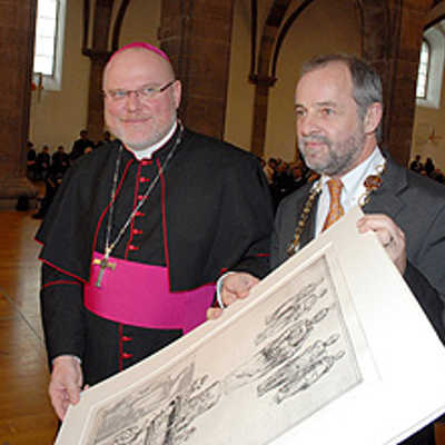 OB Jensen überreicht Bischof Marx zum Abschied eine Radierung des Petrusbrunnens von Klaus Swoboda. Zu sehen sind auch die vier Kardinaltugenden, was Jensen als Fingerzeig für die weitere Karriere von Marx interpretiert hatte. Foto: Rolf Lorig