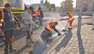 Mitarbeiter der Firma Schnorpfeil präparieren die Entwässerungsrinne am neuen Römerbrückenkreisel in Trier-West mit heißem Gussasphalt. 