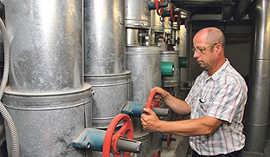 Hausmeister Uwe Mischtian bedient eine Heizpumpe im Keller des Rathauses. Eine Modernisierung der zugehörigen Regelungstechnik wird im Klimaschutzkonzept empfohlen.