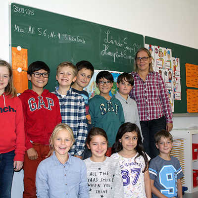 Frisch gestrichen, neue Decken und neuer Boden: Schulleiterin Hanne Modrow (rechts) freut sich mit Kindern der vierten Klasse über die Sanierung der Barbara-Grundschule. 