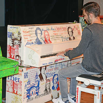 Roman Recznik spielt sich auf dem von Anja Streese gestalteten Instrument schon mal warm für die Aktion „My Urban Piano“.