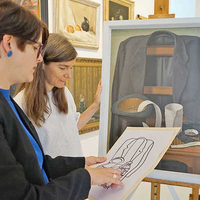 Die Kuratorinnen Dorothée Henschel (links) und Alexandra Orth vergleichen in der Ausstellung die Schwellkopie des Gemäldes von Martin Mendgen mit dem Original. Foto: Stadtmuseum