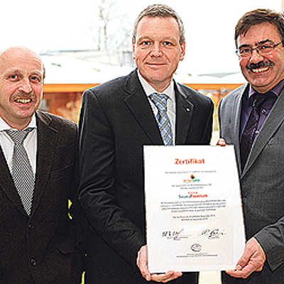Georg Bertelsbeck (B+S Finnlandsauna: Planer, Ersteller des Saunagartens), SWT-Vorstand Dr. Olaf Hornfeck und Badleiter Werner Bonertz (v. l.) mit dem Zertifikat. Foto: SWT