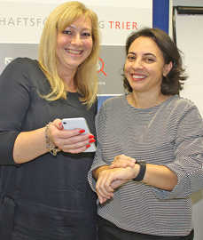 Christiane Luxem (links) und Dr. Enise Lauterbach stellen mit der Smartwatch und dem Smartphone die wichtigsten Endgeräte für die künftige „Herz-Held“-App vor. 