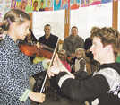 Schnupperunterricht am Tag der Offenen Tür im vergangenen Jahr: Mit Unterstützung von Musikschuldozentin Gisela Bitdinger spielt die kleine Sophie erstmals auf einer Geige.