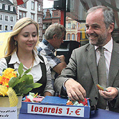 Oberbürgermeister Klaus Jensen zieht seine ersten Lose für die Stadt-Tombola 2009, die er bei Bianca Simon gekauft hat.