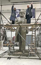 Wu Weishan zeigt Baudezernent Andreas Ludwig in seinem Atelier den Stand der Arbeit an der Karl-Marx-Statue, die ohne Sockel 4,40 Meter hoch ist. Die beiden stehen auf dem Gerüst auf einer Höhe von rund 3,50 Meter. Foto: Elisa Limbacher