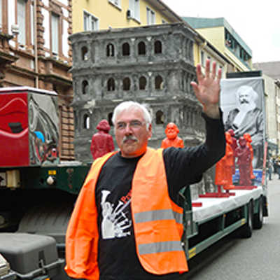 Ein Mitglied der Irscher „Pratzbähnt“-Gruppe grüßte die Besucher beim Rheinland-Pfalz-Tag. Im Hintergrund der städtische Wagen mit Porta-Modell und der Werbung für die Karl-Marx-Ausstellung.