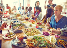Menschen treffen sich an einer Tafel mit vielen Gerichten zum Essen