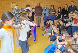 Geschminkte Kinder führen einen Tanz vor Publikum vor