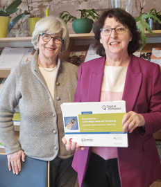 Elisabeth Ruschel, Vorsitzendes des Seniorenbüros, und Maria Dumrese, Verantwortliche für den Digitalkompass in Trier, präsentieren eines der Motive für ihre Werbeaktion.